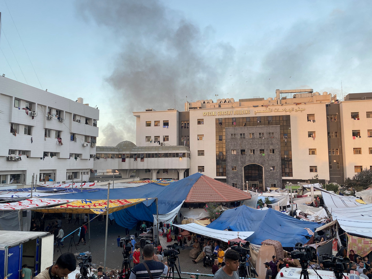 Smoke rises as displaced Palestinians take shelter at Al Shifa hospital, Nov. 8, 2023.