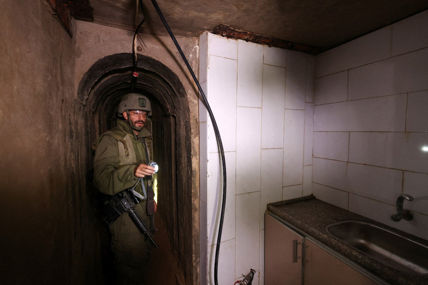 An image of an Israeli soldier standing in a room containing a sink inside a tunnel.