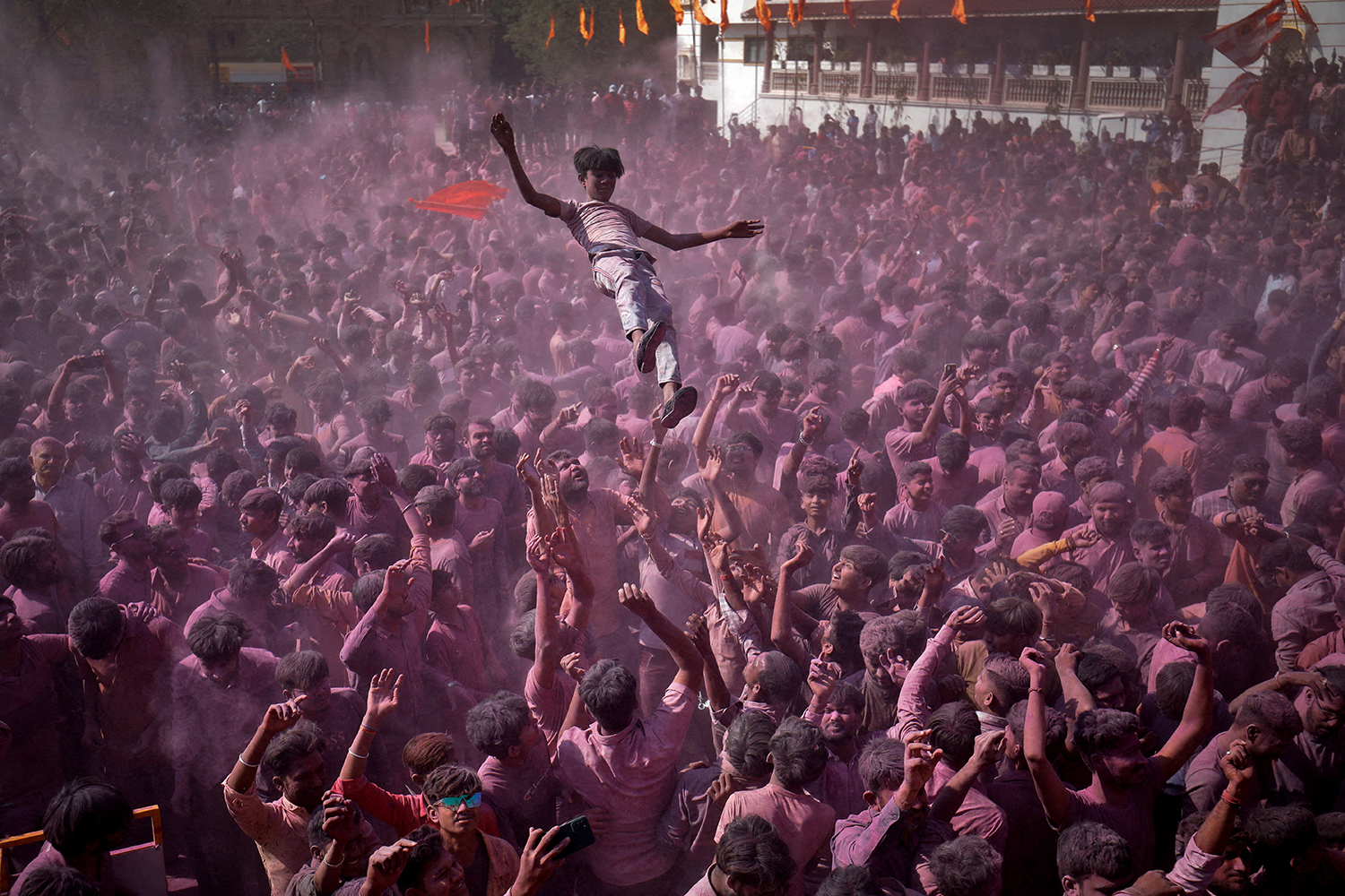 Hindu devotees daubed in colour throw a fellow devotee in the air as they celebrate Holi, the festival of colours, at a temple premises in Salangpur in the western state of Gujarat, India, March 7, 2023. REUTERS/Amit Dave
