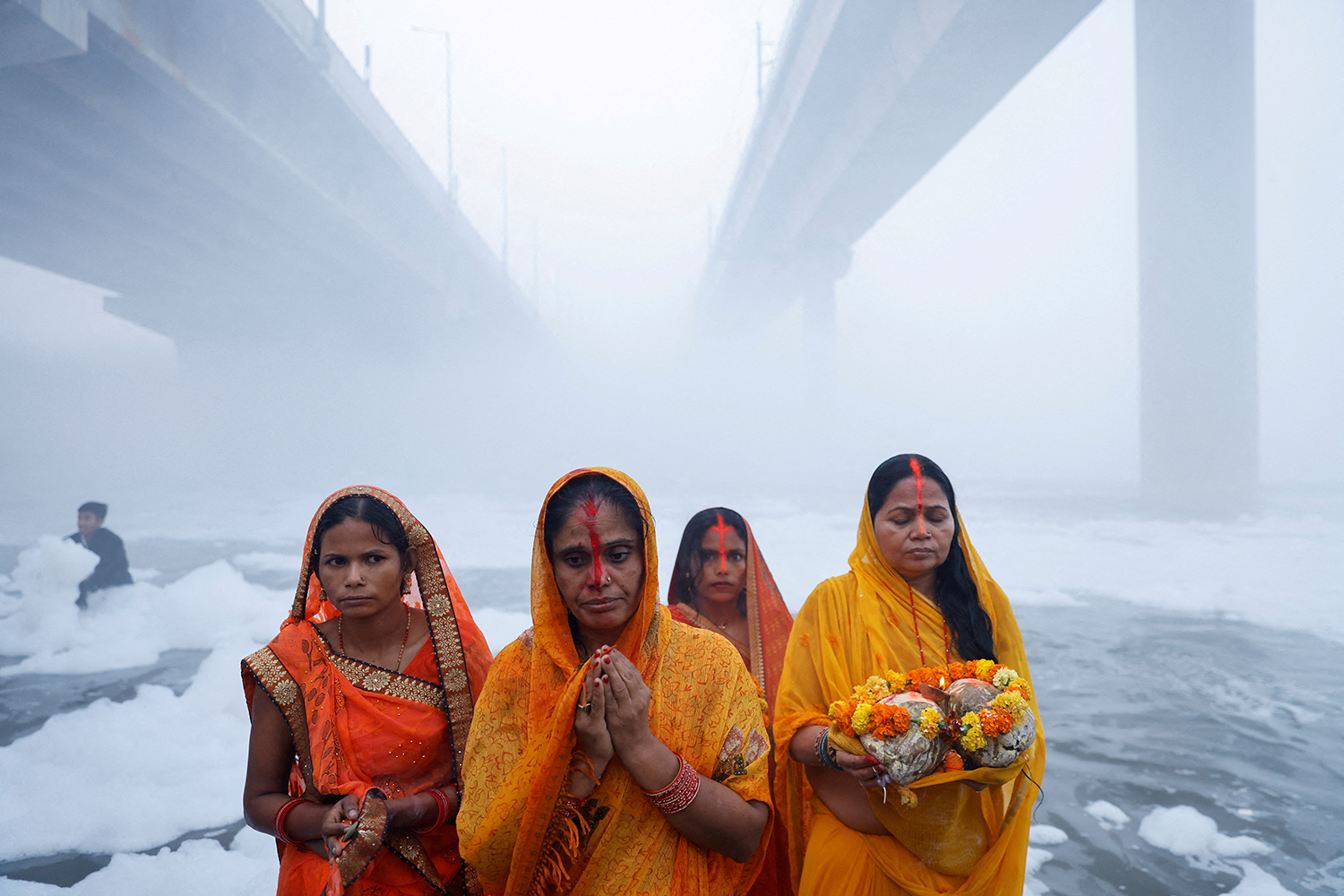 Hindu devotees worship the Sun god amidst foam covering the polluted Yamuna river during the Hindu religious festival of Chhath Puja in New Delhi, India, November 20, 2023. REUTERS/Anushree Fadnavis