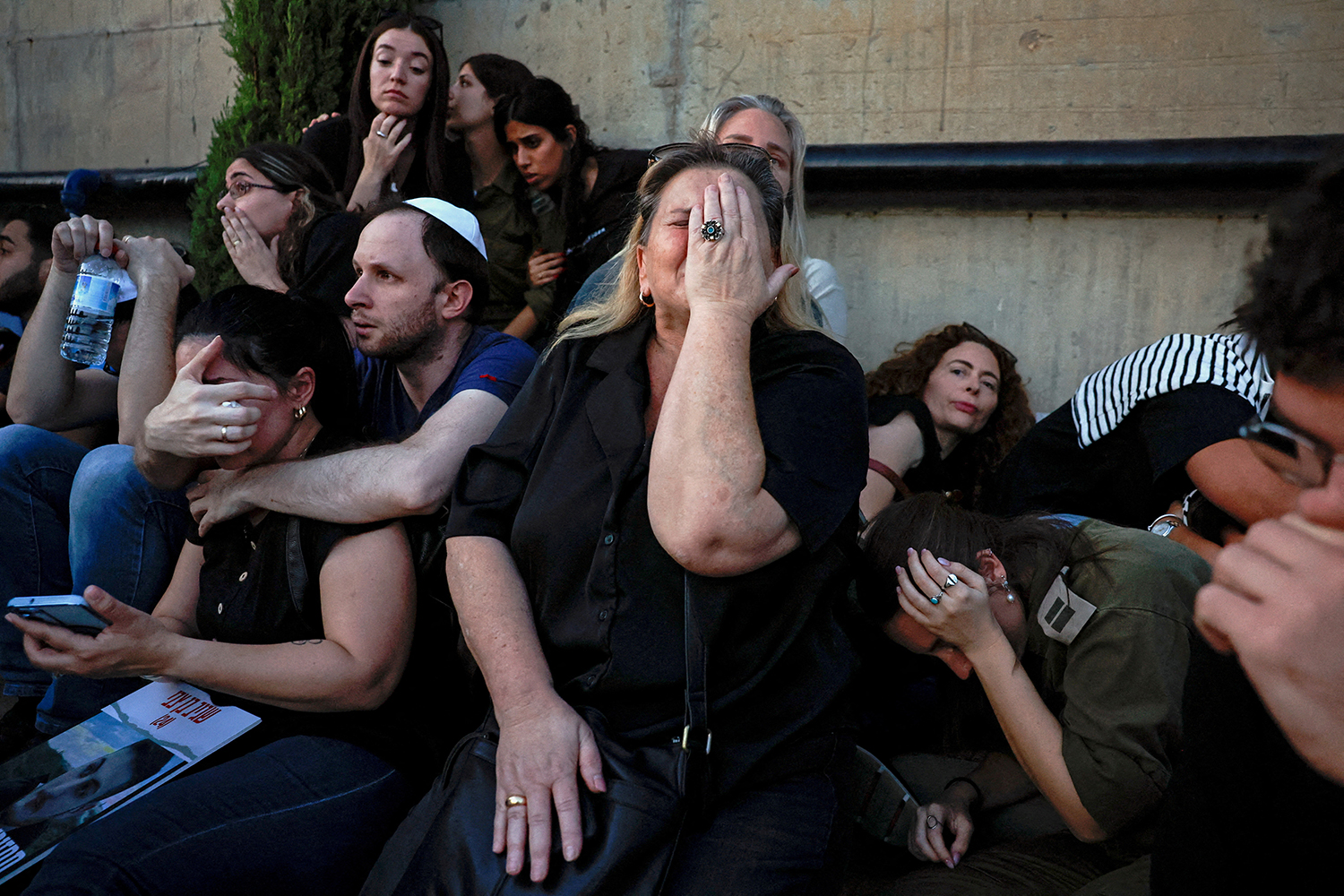 Friends and family take cover as rocket sirens sound during the funeral of Sagiv Ben Zvi, 24, who was killed following the deadly infiltration by Hamas gunmen from the Gaza Strip as he attended the Nova festival in southern Israel, in Holon, Israel, October 26, 2023. REUTERS/Evelyn Hockstein