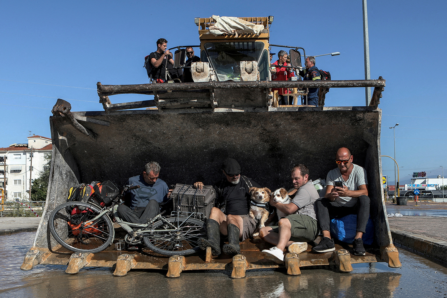 Locals are evacuated on an excavator from a flooded area in the aftermath of Storm Daniel in Larissa, Greece, September 10, 2023. REUTERS/Elias Marcou