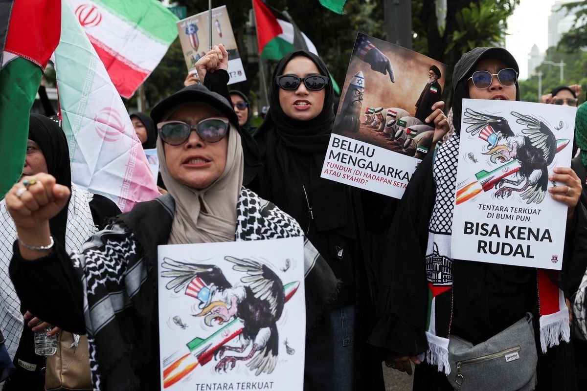 Women carry placards during a protest outside the U.S. embassy in Jakarta, Indonesia, March 9, 2026.