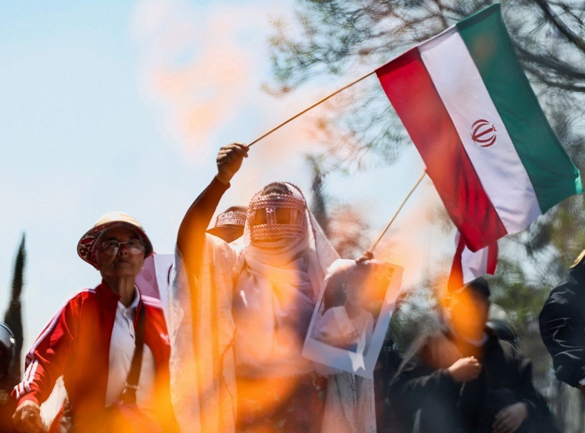 A demonstrator holds an Iranian flag while others burn an effigy during a protest outside the U.S. Embassy following the killing of Iran's Supreme Leader Ayatollah Ali Khamenei in U.S. and Israeli strikes, in Mexico City, Mexico, March 7, 2026.